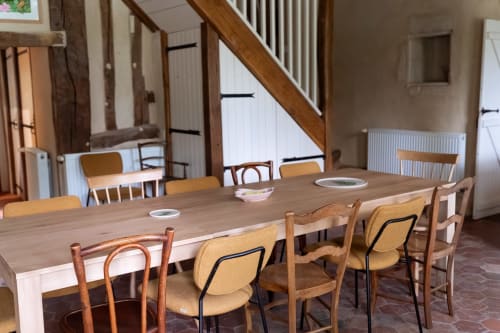 Salle à manger de la chambre d'hôtes Maisons Noisette avec table et chaises en bois, escalier, radiateurs, Saint-Pierre-des-Ormes