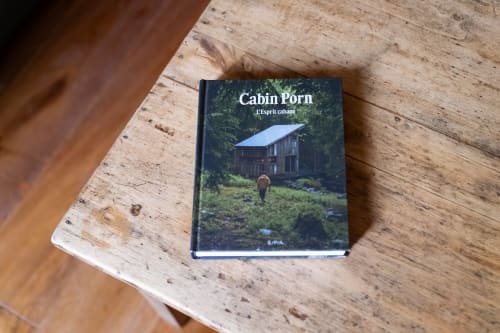 Livre Cabin Porn exposé sur une table en bois à la maison d'hôtes Maisons Noisette à Saint-Pierre-des-Ormes