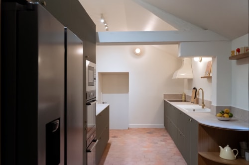 Cuisine moderne à la Maisons Noisette B&B à Saint-Pierre-des-Ormes avec armoires sombres et électroménagers en acier inoxydable