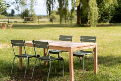 Table de salle à manger en bois avec chaises noires sur pelouse verte aux Maisons Noisette, Saint-Pierre-des-Ormes