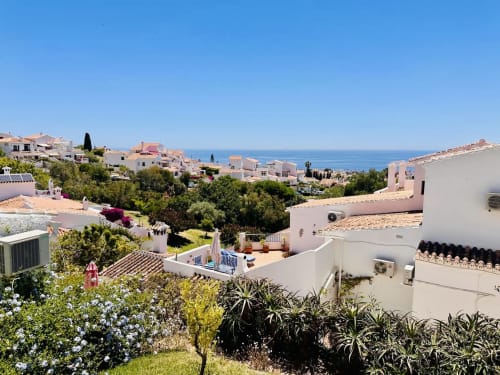 Balcón de apartamento con vistas al mar en Nerja, casas mediterráneas, jardines y horizonte azul