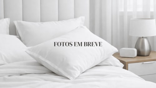 Clean bedroom at Aveiro com Paixão Living with white pillows, linens, lamp, and bedside table
