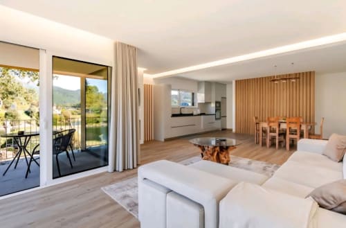 Sala de estar integrada moderna da Serração House BnB em Rio Caldo com cozinha, área de refeições e vistas da varanda