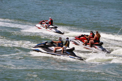 Vários jet skiers praticando esportes aquáticos nas ondas da praia de Rio Caldo, Portugal