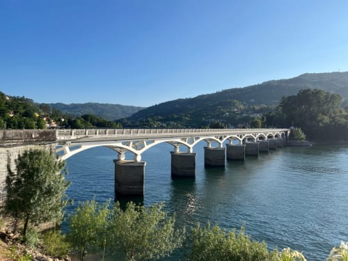 Moderna ponte sobre rio azul com colinas florestadas, Rio Caldo Portugal perto da Casa de Serração
