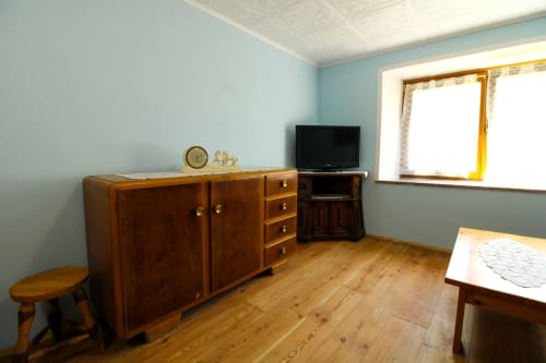 Helles blaues Schlafzimmer in der DA BEPPINESCA Unterkunft in Santo Stefano di Cadore mit Holzmöbeln, TV und Bergblick