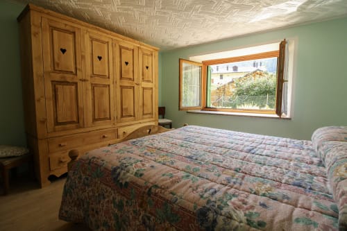Geräumiges Schlafzimmer im Apartment DA BEPPINESCA, Santo Stefano di Cadore, mit Holzkleiderschrank und Bergblick