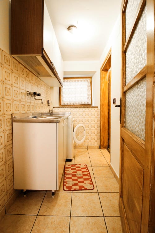 Küchenzeile in der Wohnung DA BEPPINESCA in Santo Stefano di Cadore mit Fliesenverkleidung und Holzschränken