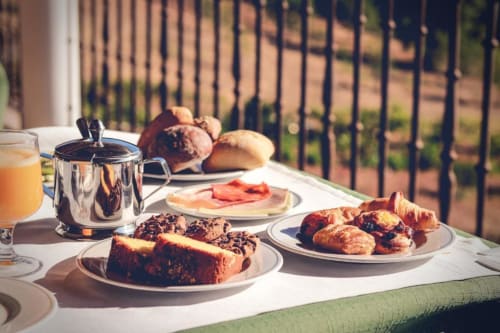 Café da manhã na Herdade da Côrte com pastelaria, pão, enchidos e sumo com vista para a campina em Tavira, Portugal