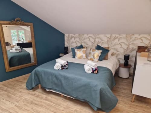 Chambre de luxe aux Villas Amboise en Guadeloupe avec mur d'accent turquoise, lits jumeaux et décoration élégante