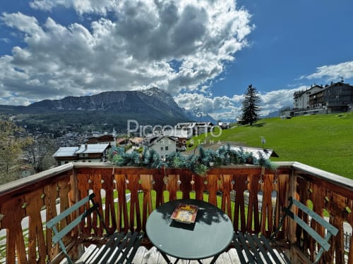Balcone in legno con vista sulle montagne presso l'Alpen Maison apartment a Cortina d'Ampezzo, Italia