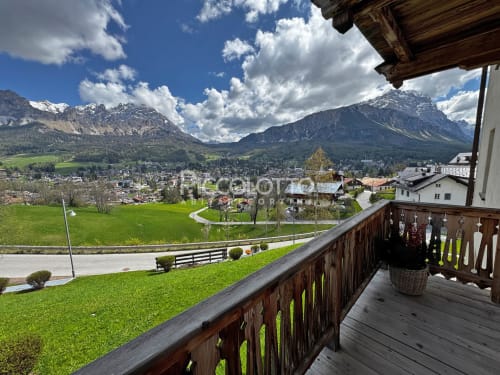 Balcone ALPEN MAISON con vista sulla valle di Cortina d'Ampezzo, Alpi innevate e prati verdi