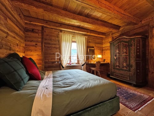 Lussuosa camera da letto in legno ad Alpen Maison, Cortina d'Ampezzo con vista montagna, camino e arredi alpini tradizionali
