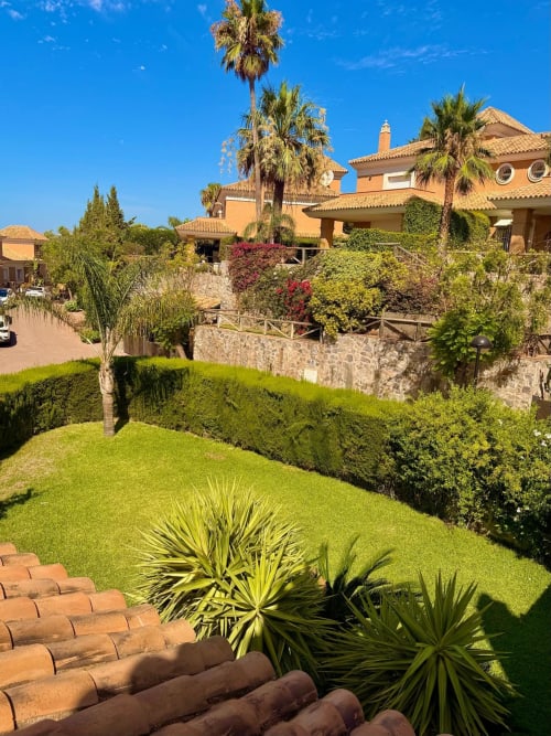 Exuberante jardín con palmeras y setos cuidados en el resort de lujo BH Marbella en España