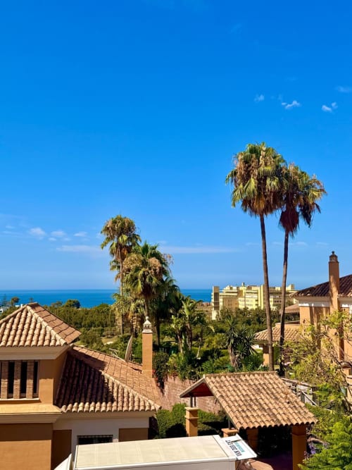 Vista costera de Marbella con palmeras, tejados de terracota y Mar Mediterráneo, España