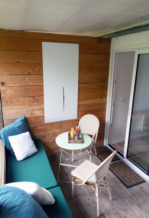 Terrazza privata moderna al Lodge du Cap Ferret con sedute turchesi, sedie bianche, tavolo rotondo e parete in legno