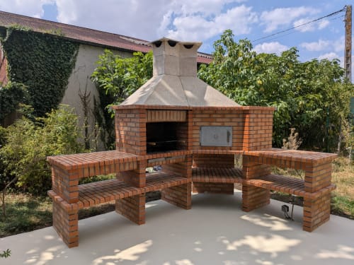 Cuisine extérieure en brique et zone de repas avec cheminée, vue jardin de la chambre Domaine de La Poule Noire