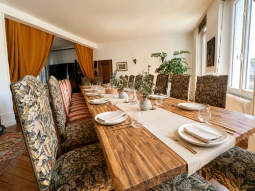 Élégante salle à manger du Domaine de La Poule Noire avec table en bois, chaises patterned et vue sur le jardin