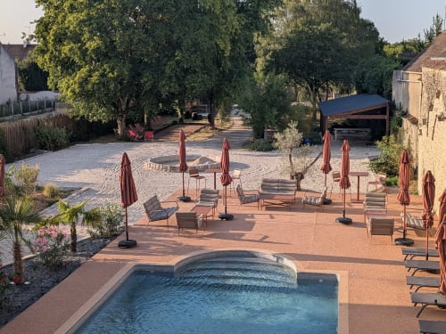 Piscine privée et jardin intérieur du Domaine de La Poule Noire avec transats, parasols et espace ombragé