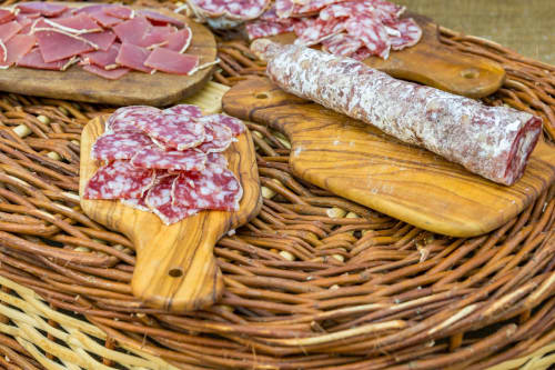 Charcuteries et saucissons présentés sur des planches en bois au gîte Madiana 89 B&B à Bellechaume