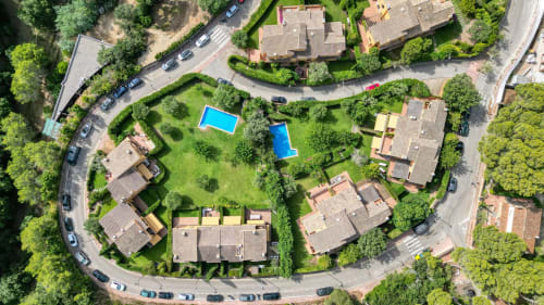 Vista aérea de la villa La Pastora en Llafranc, Palafrugell con dos piscinas azules rodeadas de exuberantes jardines mediterráneos