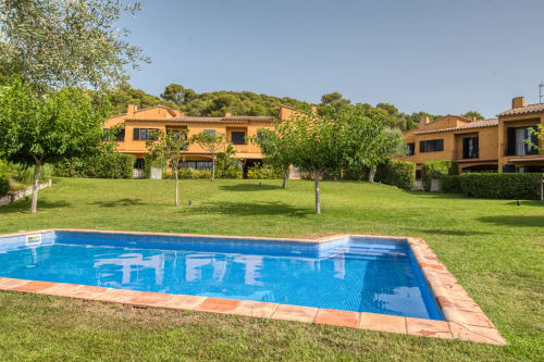 Espectacular villa La Pastora en Llafranc con piscina azul, jardines exuberantes y edificios de terracota