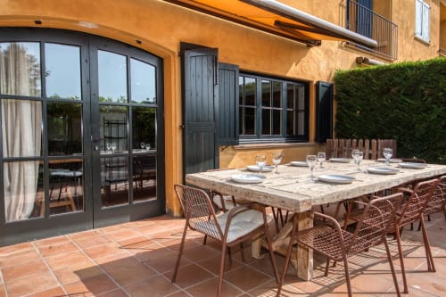 Terraza de comedor al aire libre en villa La Pastora en Llafranc, Palafrugell con mesa de piedra y sillas de mimbre