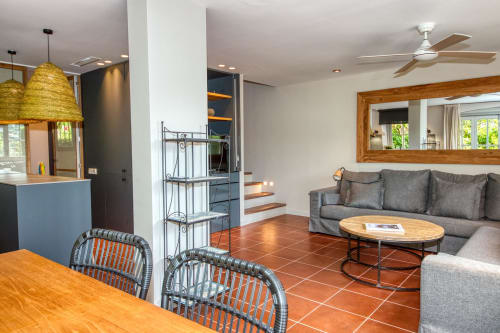 Villa moderna en Palafrugell con salón gris, comedor, cocina y suelos de terracota