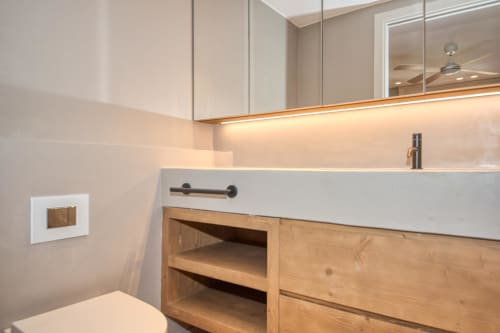 Baño moderno en la villa La Pastora, Llafranc con tocador de madera, lavamanos blanco e iluminación ambiental
