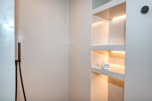 Baño moderno con estanterías empotradas e iluminación cálida en la villa La Pastora, Llafranc