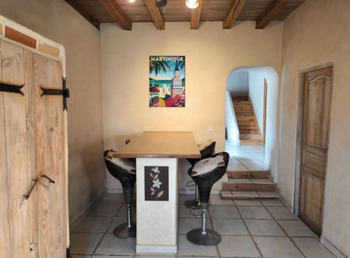 Intérieur rustique du gîte Madiana 89 avec poutres en bois, bar et art mural de la Martinique à Bellechaume.