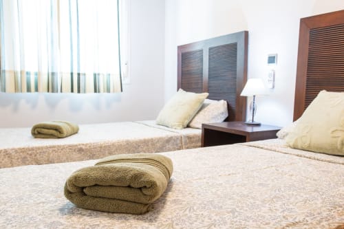 Modern bedroom at Haus Holiday Homes in San Pedro del Pinatar with two beds, wooden headboards, and neatly rolled towels