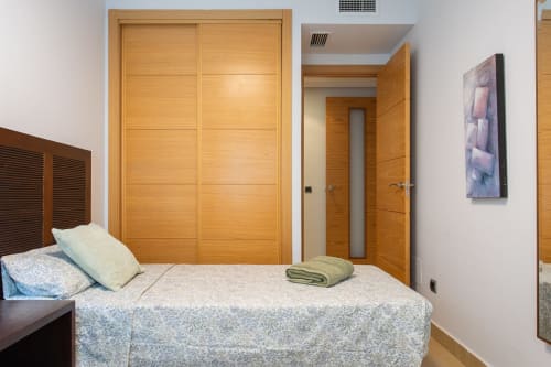 Modern bedroom with wooden wardrobe doors at Haus Holiday Homes apartment in San Pedro del Pinatar