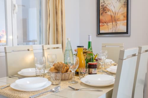 Dining table set for breakfast at Haus Holiday Homes apartment in San Pedro del Pinatar with fresh bread, beverages, and