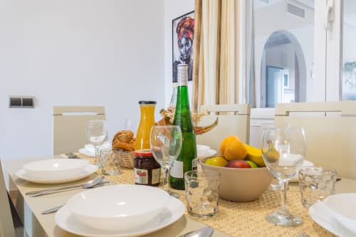 Elegant dining table set at Haus Holiday Homes apartment in San Pedro del Pinatar with wine, fresh fruit, and white tableware