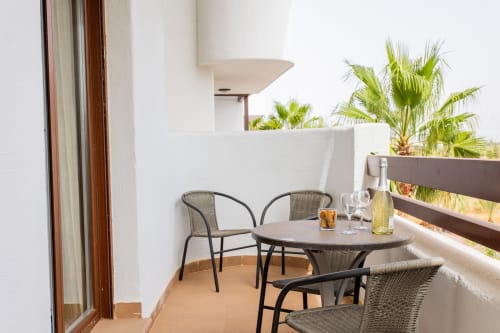 Balcony at Haus Holiday Homes in San Pedro del Pinatar with table, chairs, and palm tree views