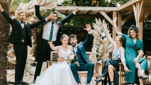 Wedding celebration at Ô Château in Hayange, France with bride, groom and guests cheering in decorated garden venue