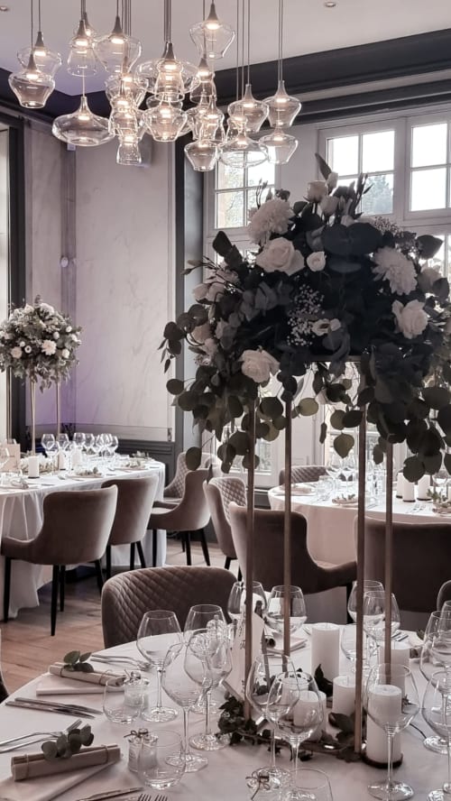 Elegant dining room at Ô Château with crystal pendant lights, floral centerpieces, and formal table settings