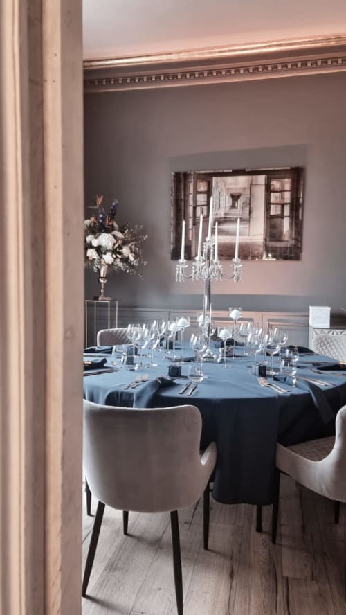 Elegant dining room at Ô Château hotel in Hayange with round table, crystal candelabra, and refined décor