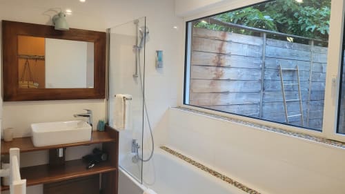 Bagno moderno al Lodge du Cap Ferret con mobile in legno, lavabo bianco a forma libera e vista sul giardino