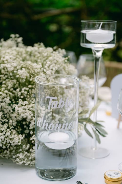 Engraved water glass with white baby's breath flowers at Ô Château hotel table setting in Hayange