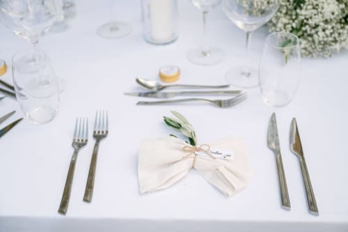 Elegant formal dining table setting at Ô Château hotel in Hayange with white linens, place card, and silverware