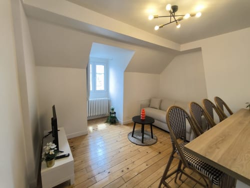 Appartement moderne et accueillant à Enghien-les-Bains avec table à manger, canapé confortable et lumière naturelle