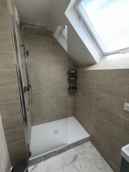Douche moderne aux carrelages beige et puits de lumière dans la salle de bain d'un appartement à Beauvais