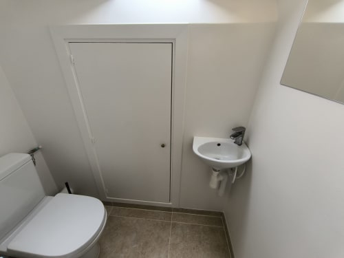 Salle de bain moderne avec toilettes, lavabo et rangements dans l'appartement Hyper Centre Beauvais