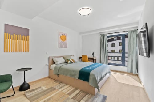 Chambre moderne chez Mattbnb Metz avec lit en bois, balcon vue sur la ville et décoration contemporaine