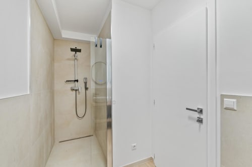 Salle de bain moderne avec douche à l'italienne, carrelage beige et porte blanche à la maison Ankoni de Mattbnb à Metz, France
