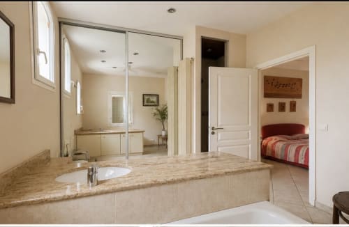 Salle de bains luxueuse à la Conciergerie Maurin à Arles avec vasque en granit, douche à l'italienne et vue sur la chambre