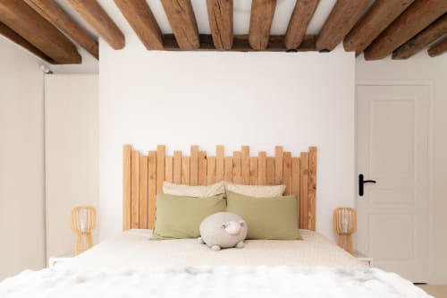 Chambre cosy des Lodges de la Ferme de la Chaise avec plafond à poutres apparentes, tête de lit en bois rustique et oreillers vert sauge