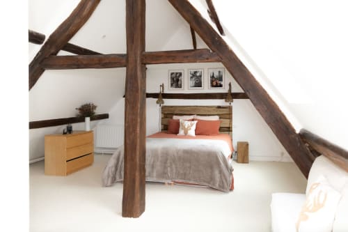 Chambre rustique avec poutres apparentes, lit queen-size aux accents orange, commode en bois et vue sur le jardin